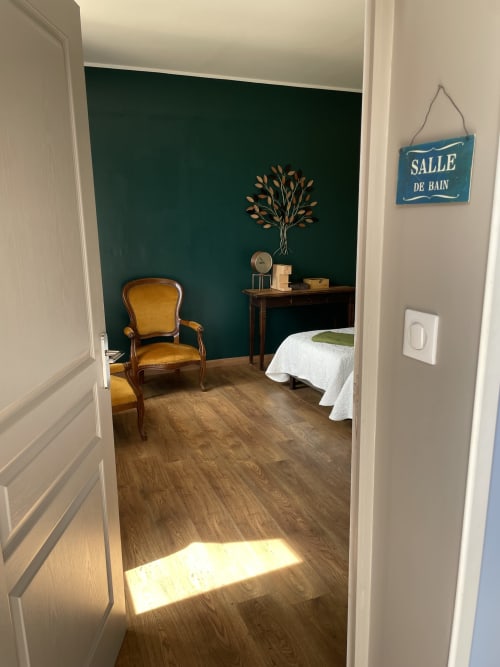 Chambre Azur bedroom at Au Bois Dormant B&B in Hesdin-la-Forêt, with teal accent wall, vintage chair, and garden view