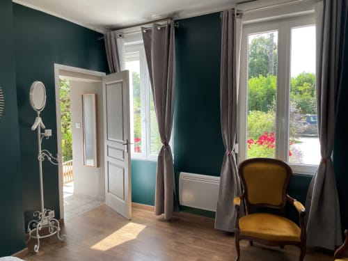Chambre Azur at Au Bois Dormant with dark teal walls, garden views through windows, and classic furnishings