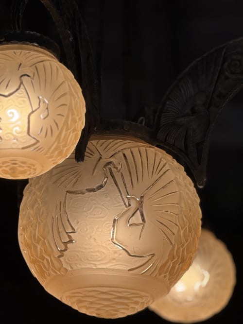 Illuminated decorative lanterns with carved face profiles at Au Bois Dormant in Hesdin-la-Forêt