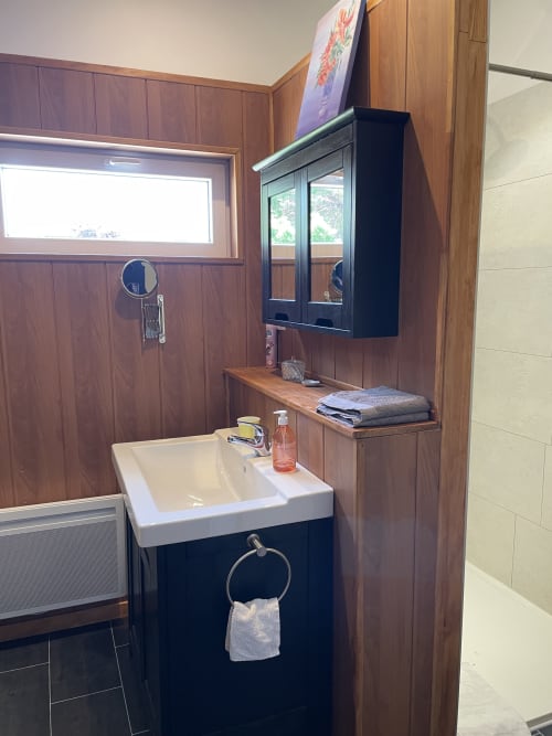 Modern bathroom at Au Bois Dormant BnB in Hesdin-la-Forêt with sink, mirror cabinet, and wooden accents