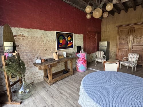 Retro room at Au Bois Dormant B&B in Hesdin-la-Forêt with burgundy walls, wooden desk, colorful artwork, and blue bedding
