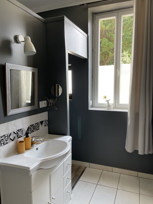 Modern bathroom in Suite Magnolia cottage at Au Bois Dormant B&B, Hesdin-la-Forêt, with black and white walls, round mirror,