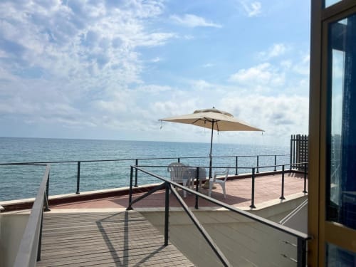 Terrazza fronte mare a Villa Mareluce a Santa Marinella, Italia con ombrellone, lettini e vista sul mare