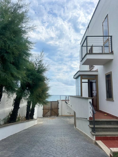 Villa moderna a Santa Marinella con vista sul mare, architettura bianca, balcone e giardino mediterraneo