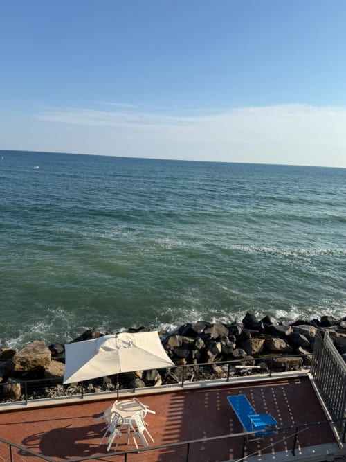 Terrazza vista mare a Villa Mareluce a Santa Marinella con lettino prendisole e costa rocciosa