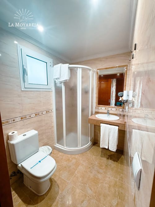 Baño moderno en Hostal La Moyareja en Rota con ducha, lavabo e inodoro