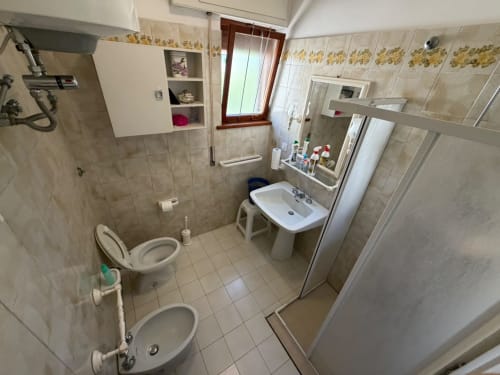 Bagno spazioso della villa Casa Bella Pantheon a Santa Marinella con doppio lavabo, doccia e piastrelle bianche
