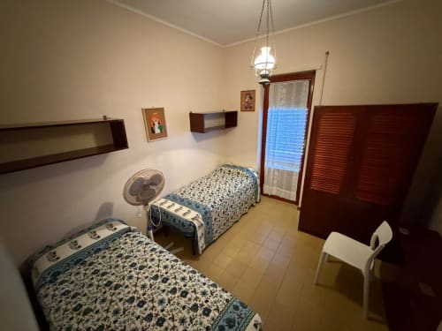 Camera doppia nella villa Casa Bella Pantheon a Santa Marinella con vista mare, arredi in legno e illuminazione a sospensione