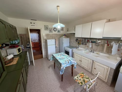Spaziosa cucina vintage della villa Casa Bella Pantheon a Santa Marinella con armadi verdi, elettrodomestici e tavolo da pranzo