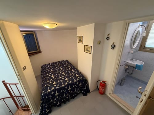 Camera compatta con copriletto nautico, ingresso bagno presso la villa Casa Bella Pantheon a Santa Marinella