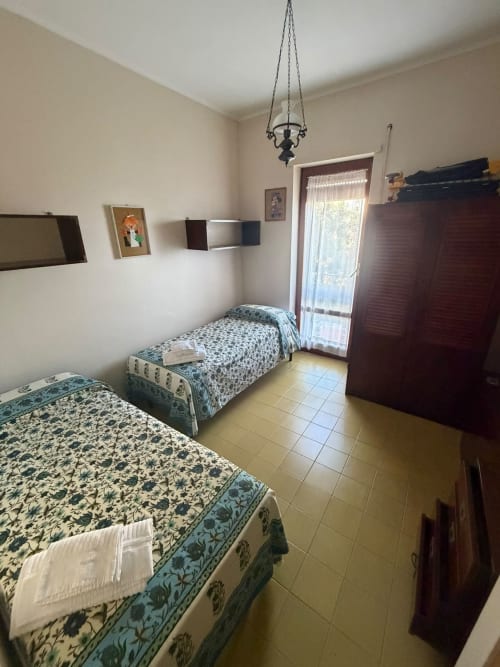 Camera gemelli a villa Casa Bella Pantheon a Santa Marinella con vista sul mare, copriletti decorati e lampada a sospensione