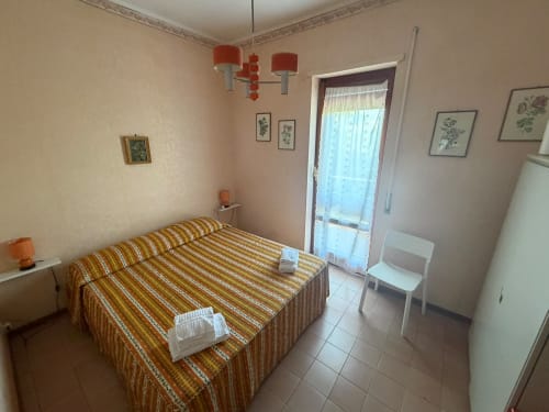 Camera luminosa nella villa Casa Bella Pantheon a Santa Marinella con letto a righe, vista sul mare e servizi moderni