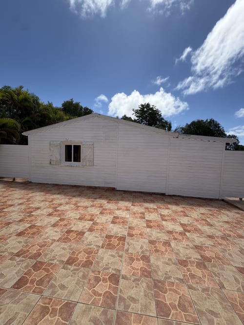 Villa blanche avec terrasse carrelée à L'Aseta Paradise à Grand-Bourg, Guadeloupe, vue sur mer et équipements extérieurs