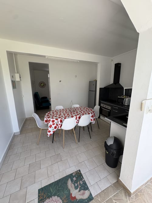 Cuisine et salle à manger modernes à L'ASETA PARADISE à Grand-Bourg avec nappe à motifs rouges et électroménagers noirs