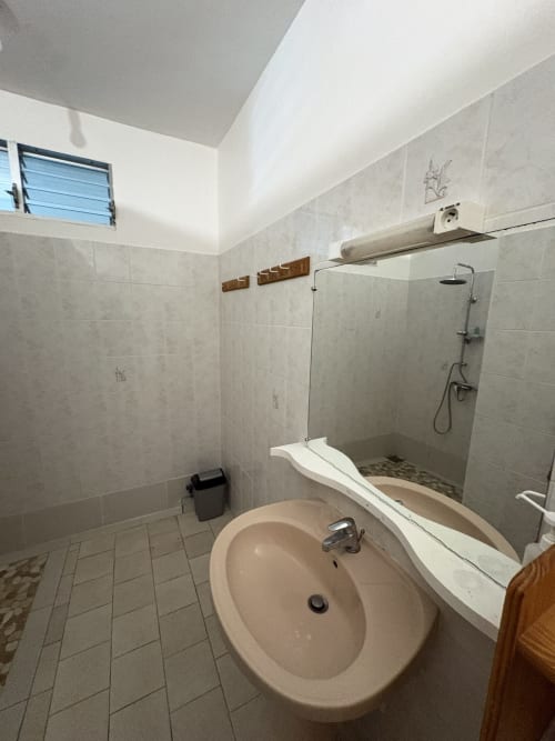 Salle de bain moderne de la villa L'Aseta Paradise, Grand Bourg, avec lavabo rond, douche vitrée et carrelage