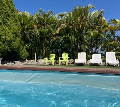 Piscine de la villa L'Aseta Paradise avec chaises citron vert, palmiers et transats à Grand-Bourg, Guadeloupe