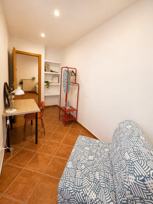 Monolocale moderno a Castelli Apartments con zona living, scrivania, divano letto e pavimento in cotto