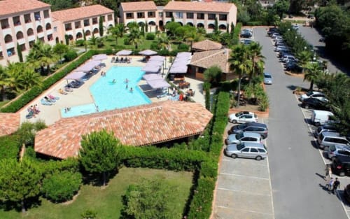 Vue aérienne de la Résidence de Vacances SOGNU DI MARE à Linguizzetta avec piscine, bâtiments en terre cuite et parking