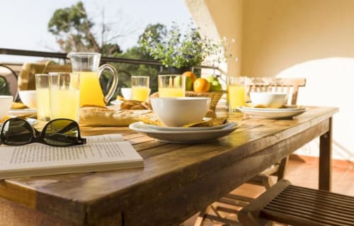Petit-déjeuner ensoleillé sur la terrasse de l'appartement SOGNU DI MARE à Linguizzetta avec jus frais, viennoiseries et vue sur mer
