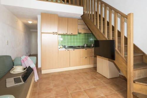 Cuisine moderne et séjour avec escalier en bois à l'appartement SOGNU DI MARE à Linguizzetta, crédence verte