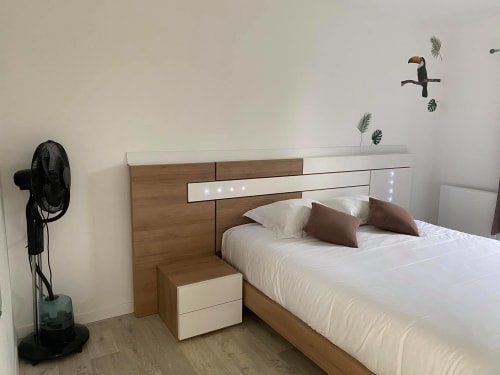 Chambre moderne aux Gîtes de la Vallée de l'Artois avec tête de lit en bois, literie blanche et décoration murale contemporaine