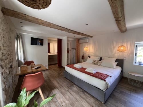 Chambre spacieuse à La Maison de Vaison B&B à Vaison-la-Romaine avec poutres apparentes, mobilier moderne, TV et salle de bain privée