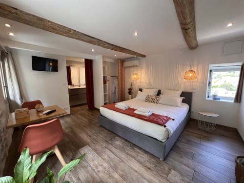 Chambre moderne à La Maison de Vaison à Vaison-la-Romaine avec lit queen, poutres apparentes, salle de bains attenante, rez-de-chaussée