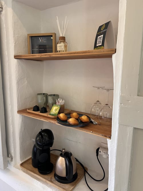 Étagères intégrées en bois à La Maison de Vaison présentant cafetière, verres, bougies et décoration