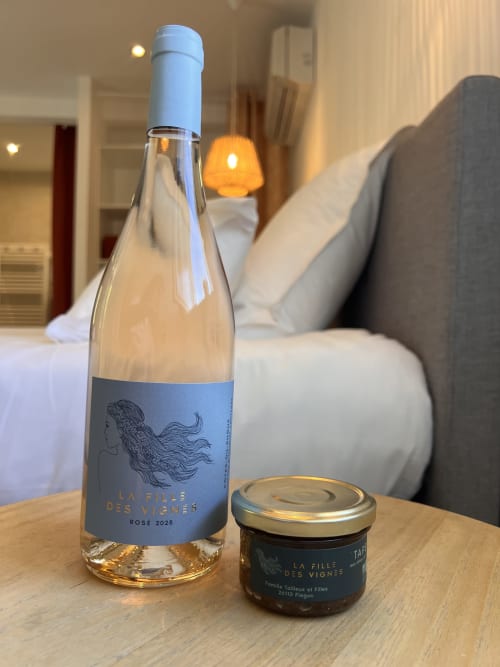 Bouteille de rosé et tapenade locale de La Fille des Vignes sur table en bois dans une chambre de La Maison de Vaison