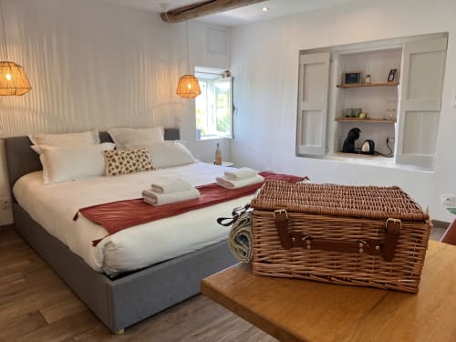 Chambre lumineuse à La Maison de Vaison avec lit confortable, malles en osier et rangements intégrés