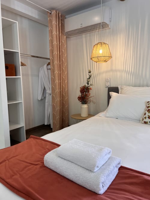 Chambre cosy à La Maison de Vaison B&B avec literie blanche, suspension tissée et touches de terre cuite
