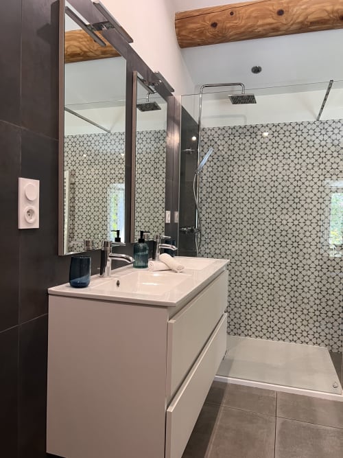 Salle de bain moderne à La Maison de Vaison avec vasque blanche, douche ouverte carrelée géométrique et poutres en bois