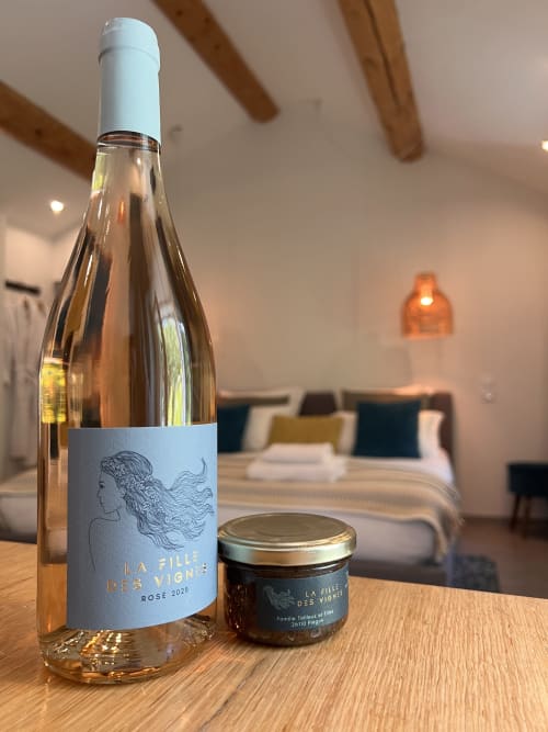 Vin rosé La Fille des Vignes et confiture locale sur table en bois dans une chambre d'hôtel à Vaison-la-Romaine