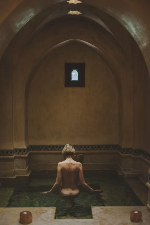 Femme en méditation dans la piscine voûtée du spa de l'hôtel Eucalyptus Ethnic à El Ghazouane, Maroc