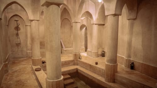 Hammam spa luxueux à l'hôtel Eucalyptus Ethnic avec plafonds voûtés, colonnes en marbre et bancs en pierre chauffée à El