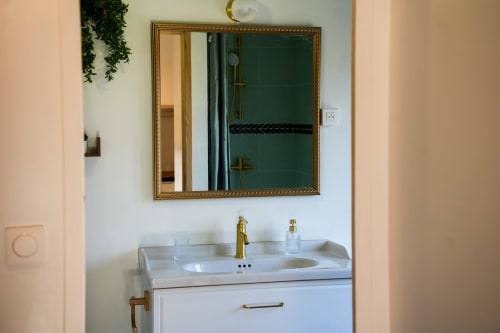 Lavabo de salle de bain moderne avec robinetterie dorée à Les séjours Ardennais, appartement Escapade Chic à Renwez