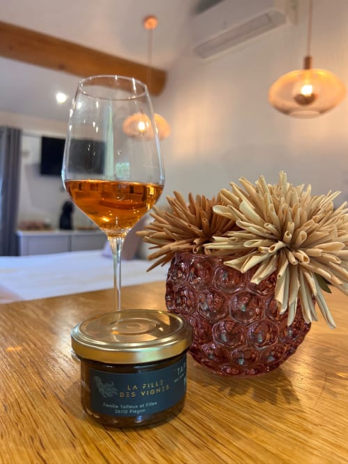 Verre de rosé, pot de produit artisanal local et fleurs séchées sur table en bois à La Maison de Vaison