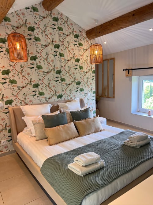 Chambre élégante à La Maison de Vaison avec papier peint floral, literie blanche et deux luminaires suspendus