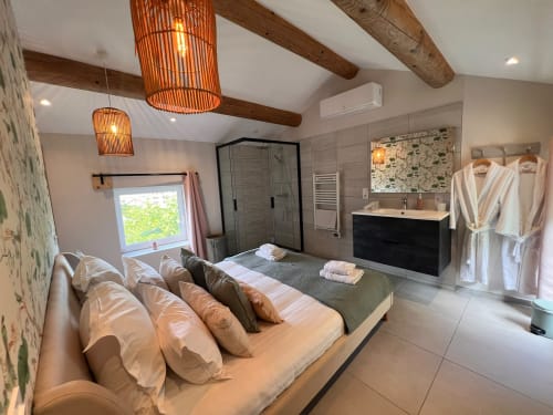 Chambre et salle de bain ouvertes luxueuses à La Maison de Vaison BnB à Vaison-la-Romaine avec équipements modernes et poutres apparentes