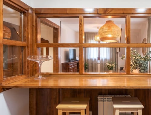 Mostrador de madera con copas de vino y lámpara colgante en el hotel El Aserradero de La Alberca, Salamanca