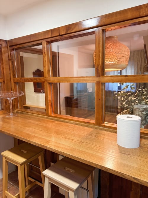 Encimera de madera en apartamento El Aserradero con taburetes de comedor y vistas al jardín en La Alberca
