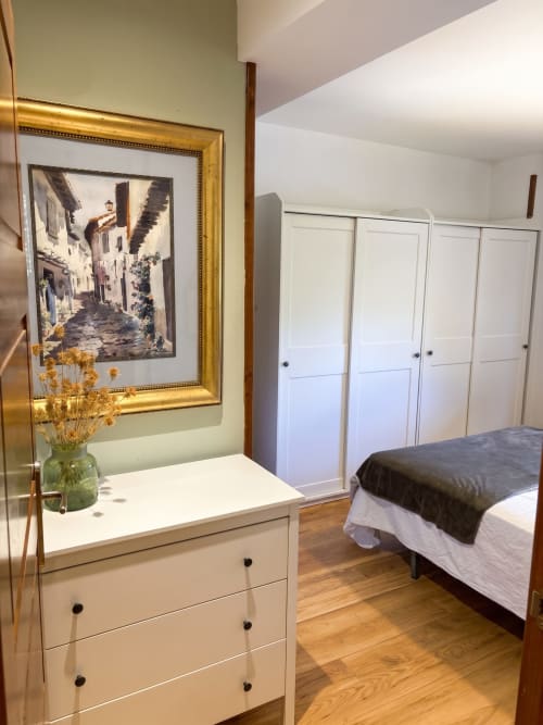Dormitorio en El Aserradero, La Alberca con cómoda blanca, cuadros enmarcados, cama con manta oscura y puertas de armario blanco