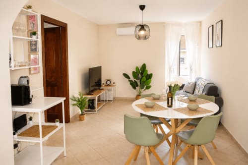 Zona living e pranzo moderna negli Appartamenti Castelli a Castel Gandolfo con tavolo rotondo, sedie verdi, divano e