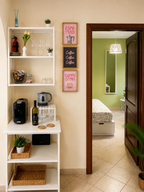 Angolo bar caffè nell'appartamento Castrum Home con macchinetta per espresso, vini e decorazioni a tema caffè a Castel Gandolfo