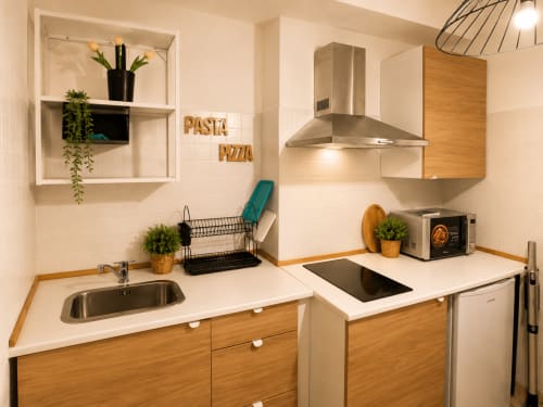 Cucina moderna con mobili in legno, elettrodomestici in acciaio inox e piano di lavoro bianco nell'appartamento Castrum Home, Castel