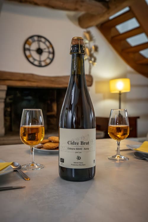 Bouteille de Cidre Brut avec deux verres remplis à la Ferme de Kervihern, Locoal-Mendon, mise en place élégante