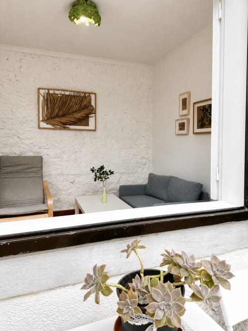 Quarto privativo Casa da Anita em Villas Simone Porto Santo com paredes de tijolos brancos, móveis cinzentos, arte botânica e