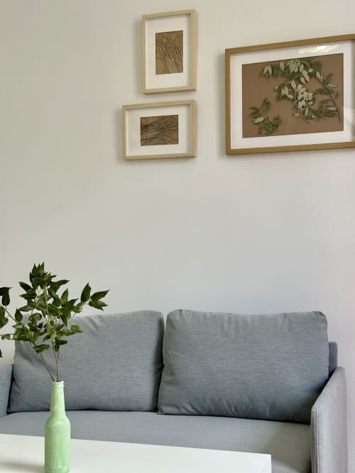 Sofá cinza com vaso de planta verde em Casa da Anita nas Villas Simone Porto Santo, arte botânica acima