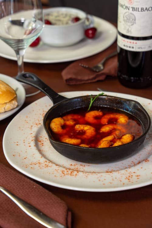 Gastronomisch garnalenschotel in gietijzeren pan bij restaurant Hotel Balcón De Los Montés, Colmenar