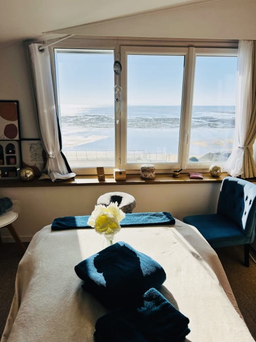 Strandschlafzimmer mit Meerblick in der Villa Plein Vent, Barneville-Carteret, mit Handtüchern und gelben Blumen